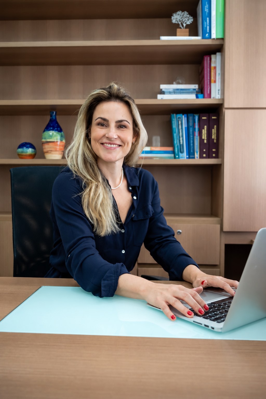 Dra. Fernanda Asencio no consultório, ao notebook